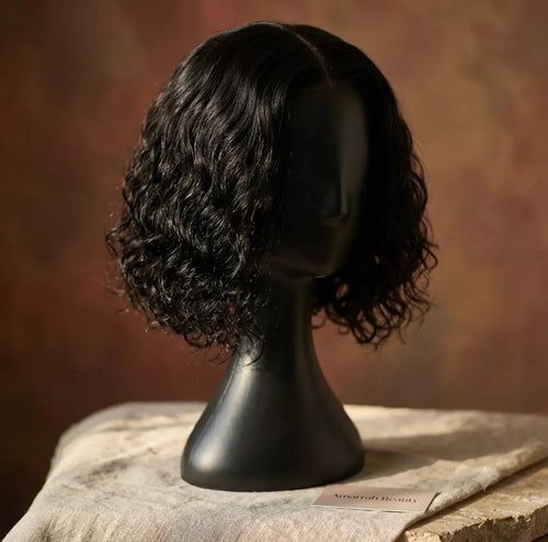 10 inch Deep Wave Curly Bob Wig on black mannequin head, side profile view, warm terracotta background — Amarrah Beauty